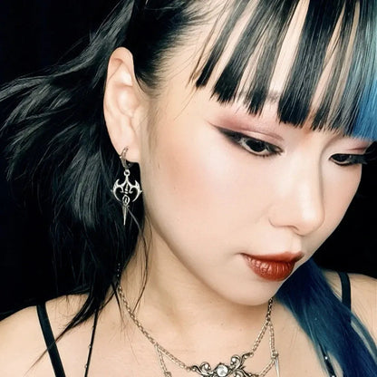 Longinus Halo Piercer Earrings in 925 sterling silver, worn in a portrait with blue-black hair, blunt bangs, and layered silv
