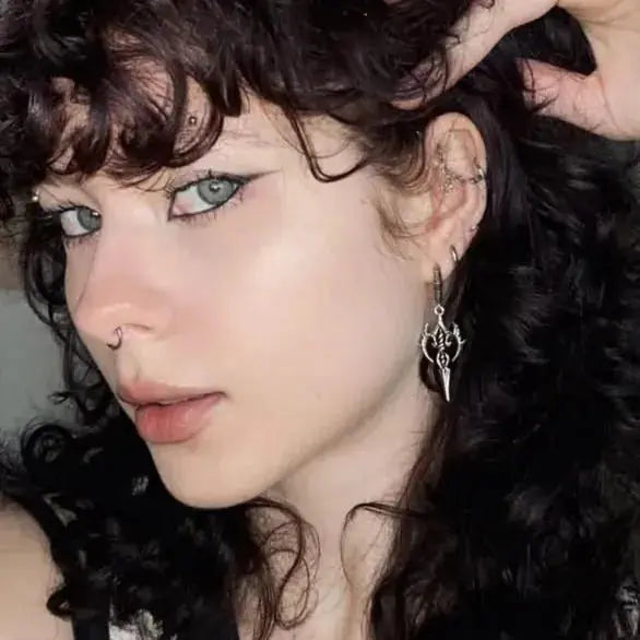 Longinus Halo Piercer Earrings in 925 sterling silver, worn in a close portrait with curly dark hair and soft neutral makeup.