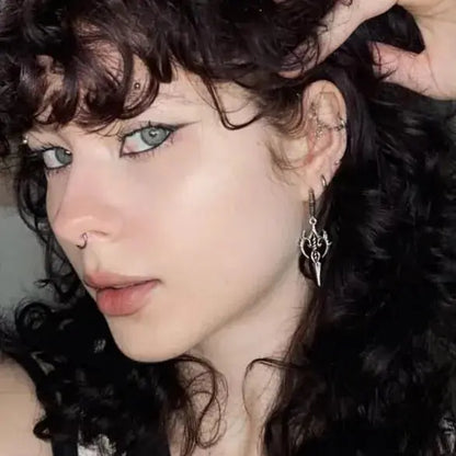 Longinus Halo Piercer Earrings in 925 sterling silver, worn in a close portrait with curly dark hair and soft neutral makeup.