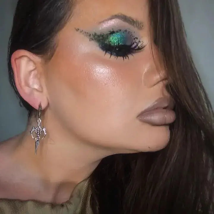 Longinus Halo Piercer Earrings in 925 sterling silver, worn in side profile with dramatic green eye makeup and a glossy highl