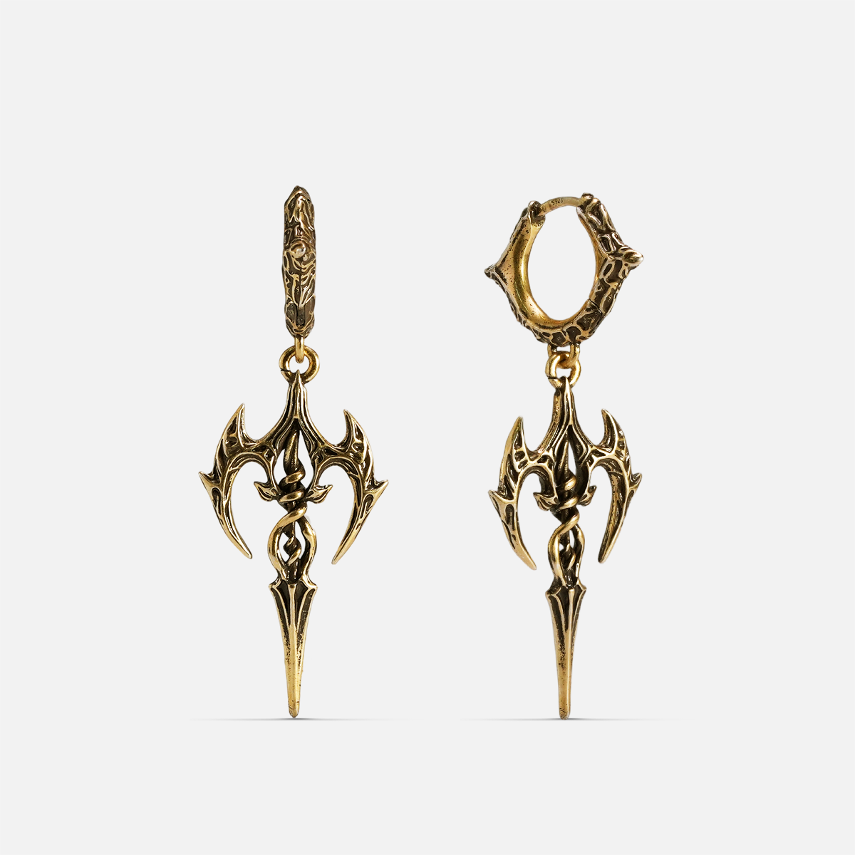 Pair of antique gold-tone halo piercer earrings with spear-shaped pendants laid flat, front and side view