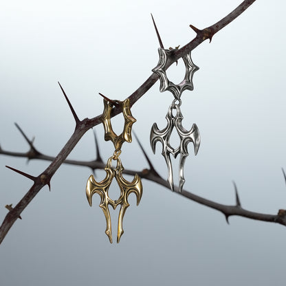 Gold and silver Longinus Judgment Talon earrings hanging from thorn branches