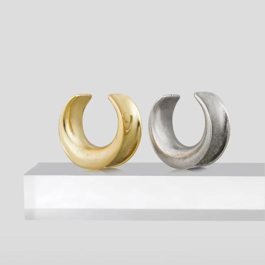 Gold and silver Lunar Eclipse tunnels displayed on a white pedestal