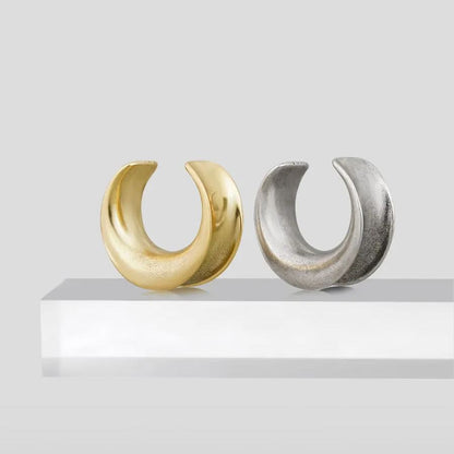 Gold and silver Lunar Eclipse tunnels displayed on a white pedestal