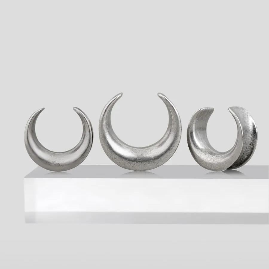 Three sizes of silver Lunar Eclipse tunnels displayed on a white pedestal