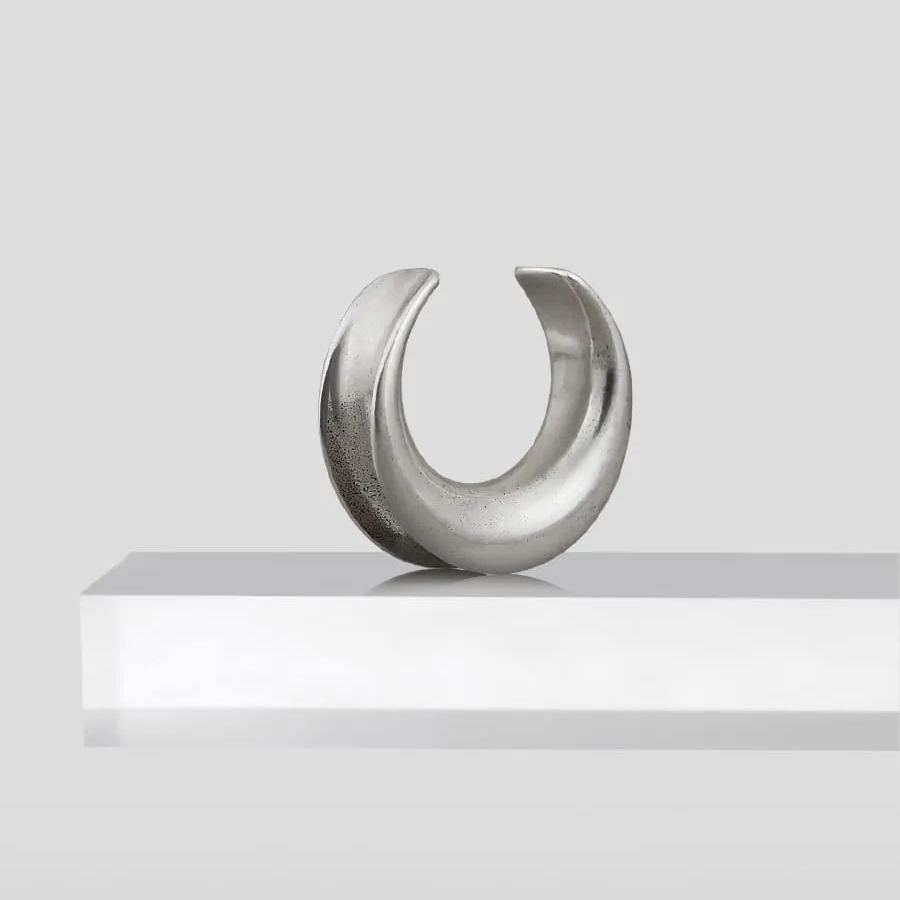 Single silver Lunar Eclipse tunnel displayed upright on a white pedestal