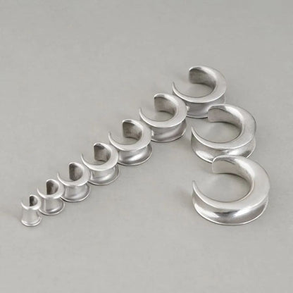 Silver Lunar Eclipse tunnels in graduated sizes arranged on a white surface