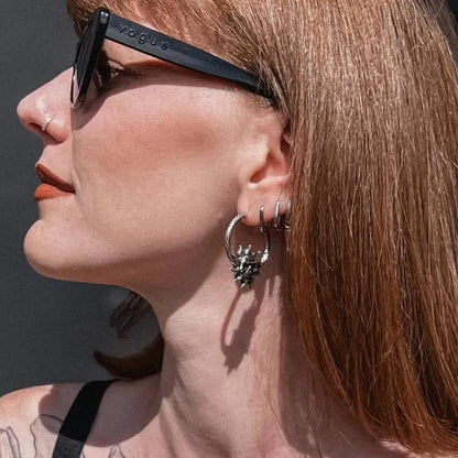 Model wearing silver Lunar Solar Skulls Earrings with moon skull hoop design and gothic celestial styling
