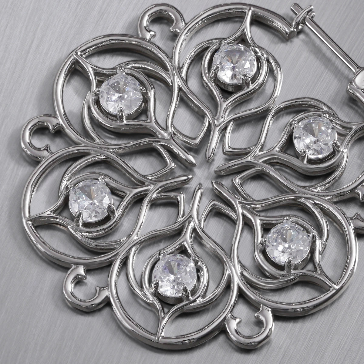 Close-up of silver Mandala Bloom earring with clear center accents