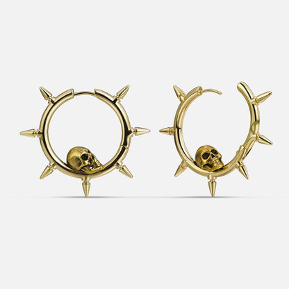 Gold-tone spiked hoop earrings featuring a skull charm nestled within each hoop
