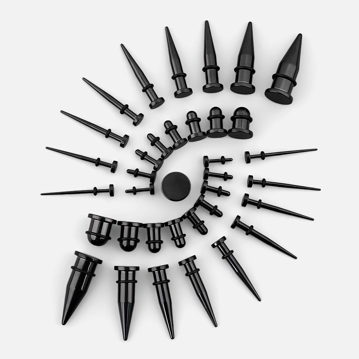 Black stainless steel ear tapers of various gauges arranged in a spiral pattern on a light background