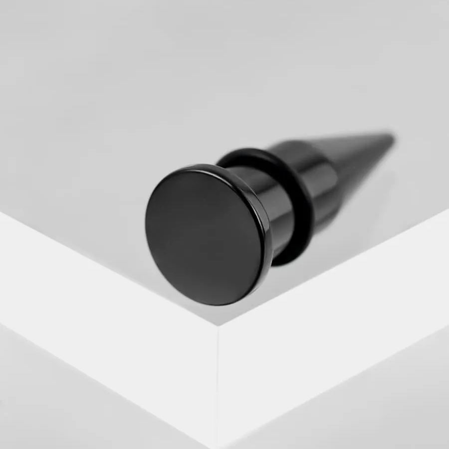 Close view of a black stainless steel ear taper with round flat back and rubber o-ring
