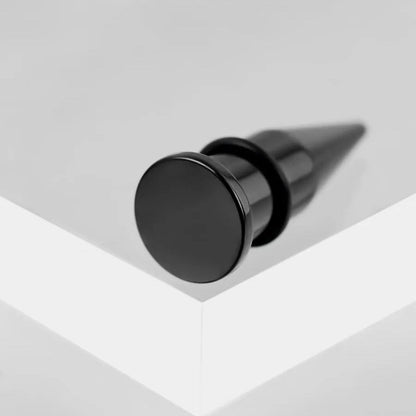 Close view of a black stainless steel ear taper with round flat back and rubber o-ring