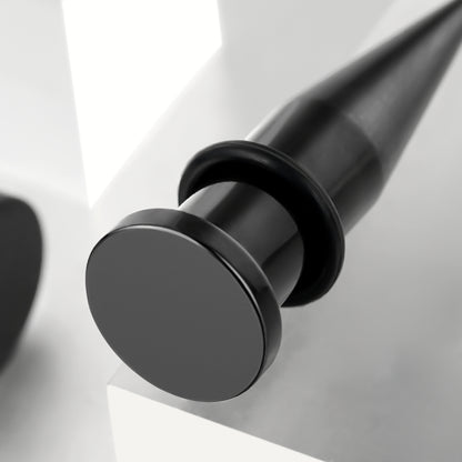 Angled close-up of a black stainless steel ear taper showing tapered point and o-ring detail