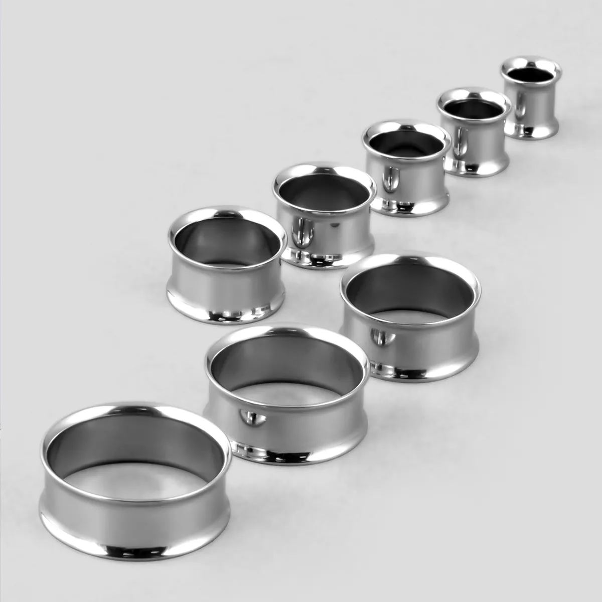 Minimalist Loop titanium tunnels in graduated sizes arranged on a light surface