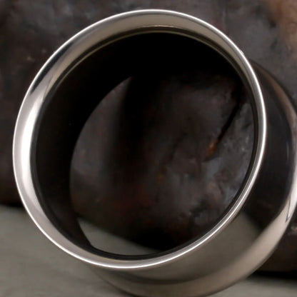 Close-up of silver Minimalist Loop titanium tunnel with smooth flared rim