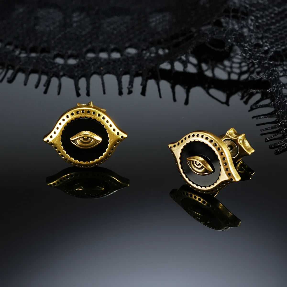 Gold-tone Mirror Witness Stud Earrings displayed from front and side views on a dark reflective surface.