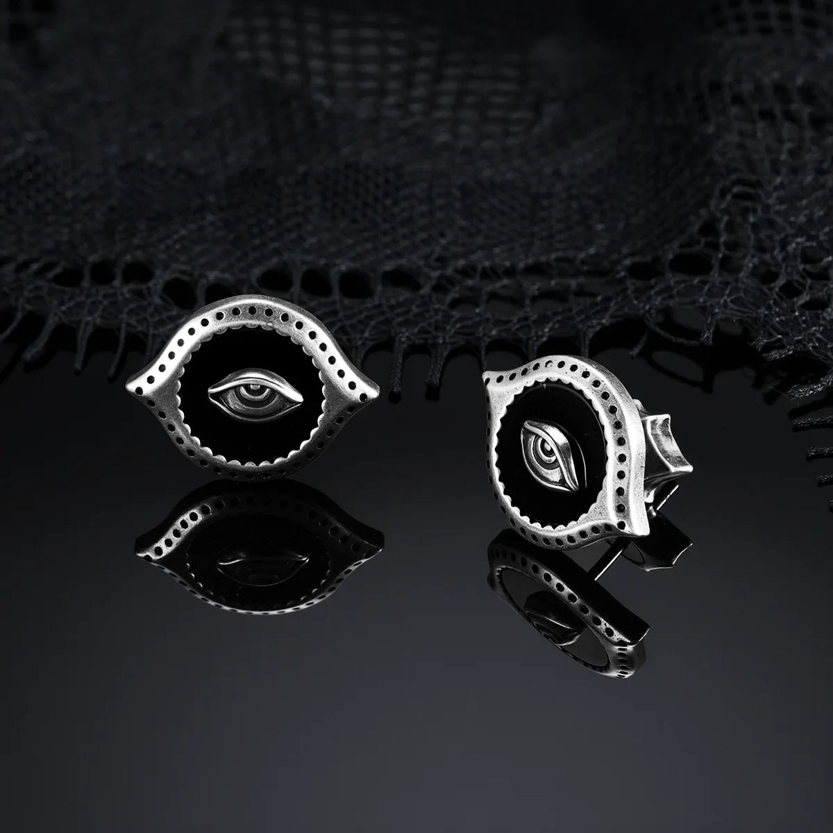 Antiqued silver-tone Mirror Witness Stud Earrings displayed from front and side views on a dark reflective surface.