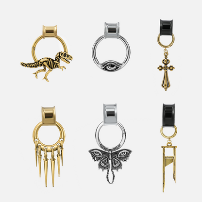 Six modular ring tunnel styles in gold, silver, and black with dinosaur, eye, cross, spike, moth, and bar charms