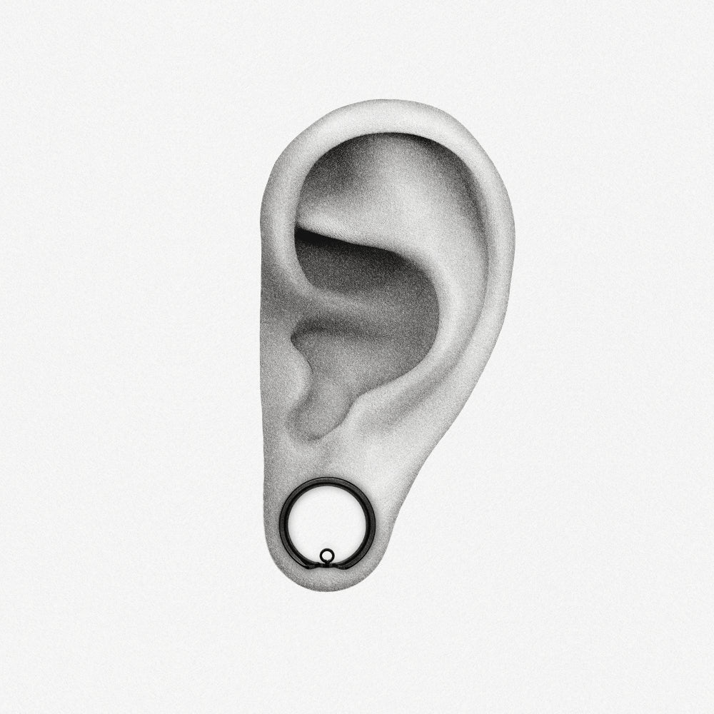 Black modular ring tunnel positioned in an illustrated earlobe to show the worn fit
