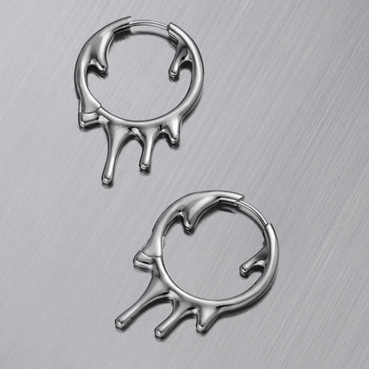 Molten Drop Earrings in 925 sterling silver, pair arranged flat on a brushed metal surface to show the molten shape from two 