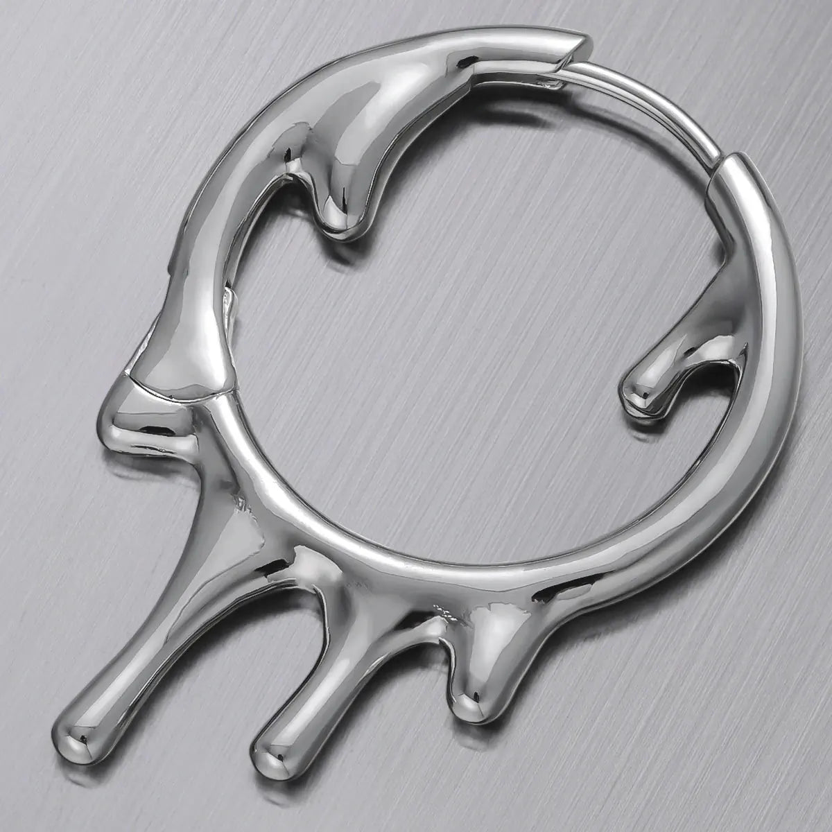 Molten Drop Earrings in 925 sterling silver, single hoop shown in a close product detail on a brushed metal surface.