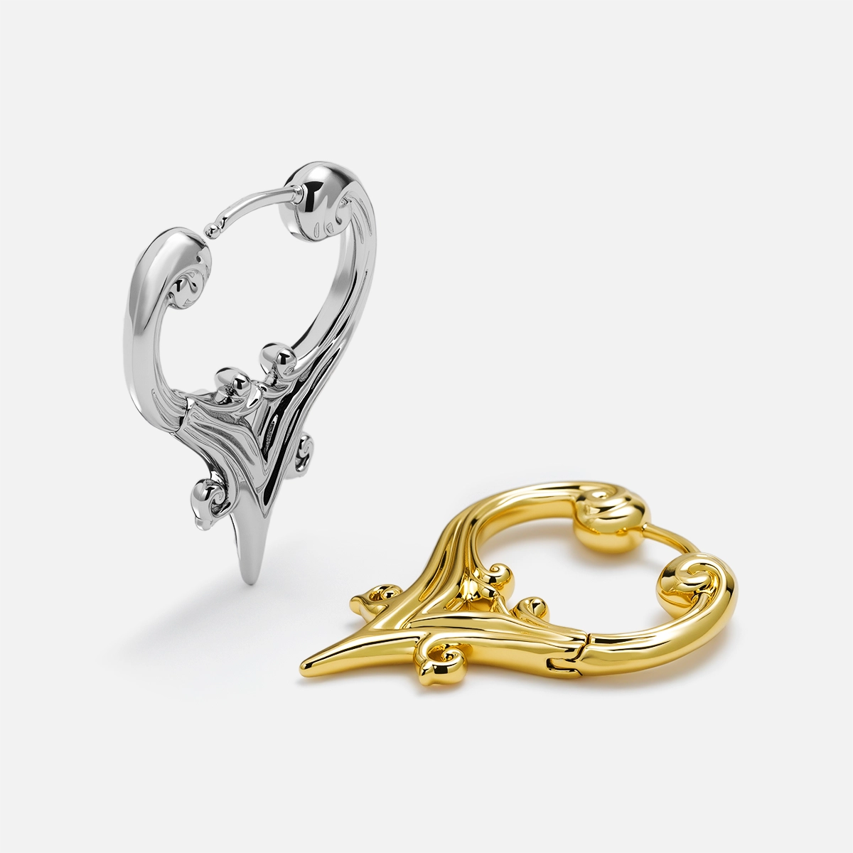 Silver and gold Mystic Crest heart hoop earrings shown open and lying flat