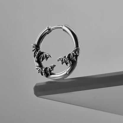 Silver Mystic Insight hoop earring casting a shadow on a light surface