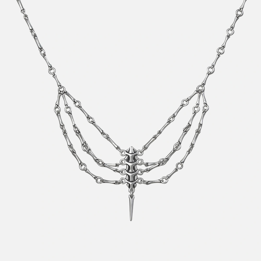Silver-tone spine necklace with layered chains and a spike pendant, shown flat on a plain background
