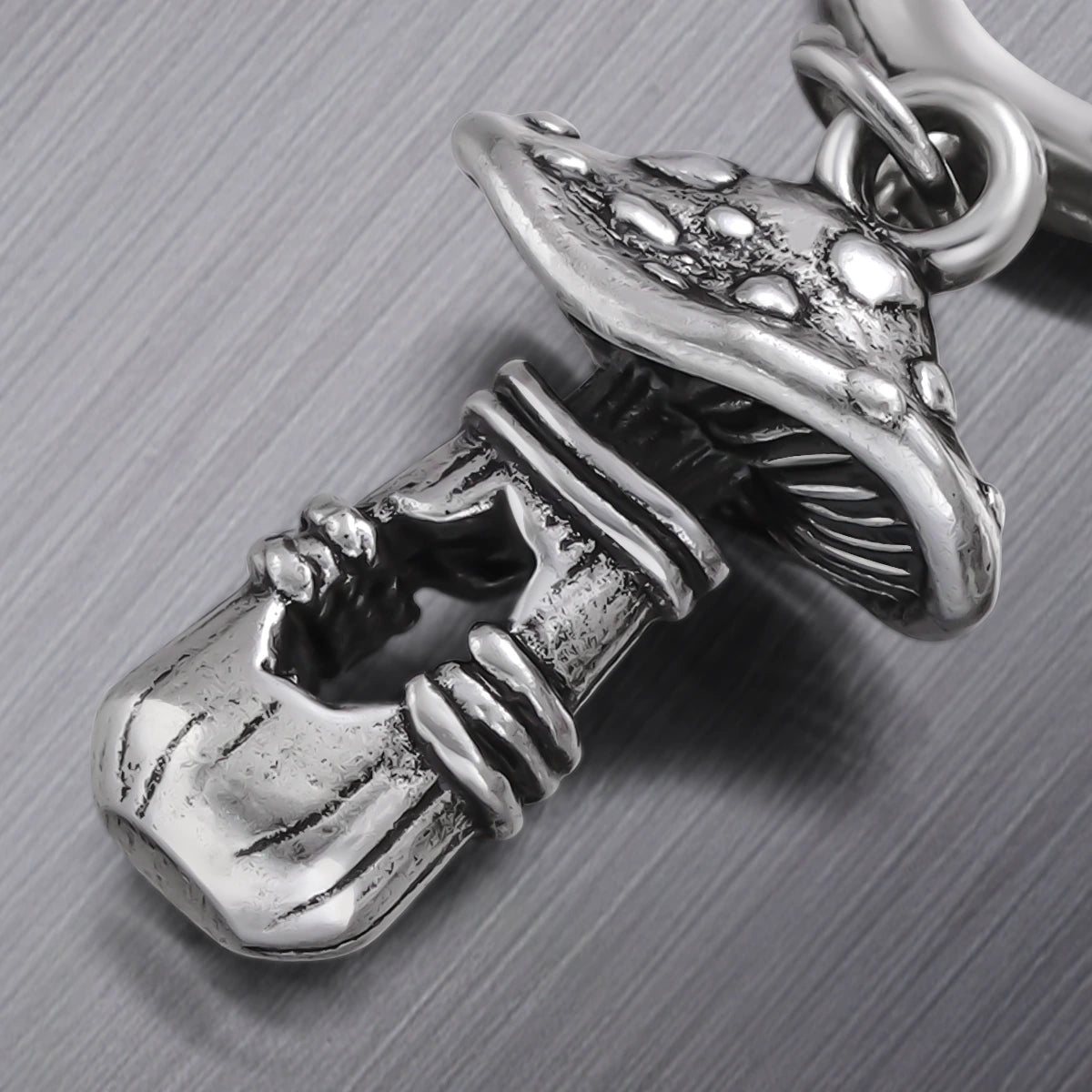 Close-up of silver Mystical Mushroom earring with textured cap and stem details