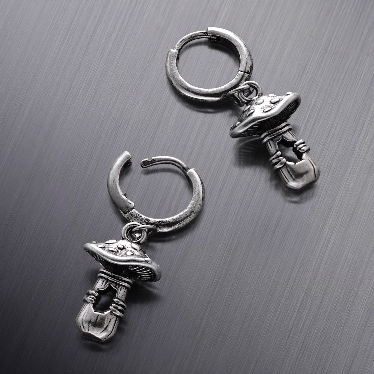 Three silver Mystical Mushroom hoop earrings shown from different angles