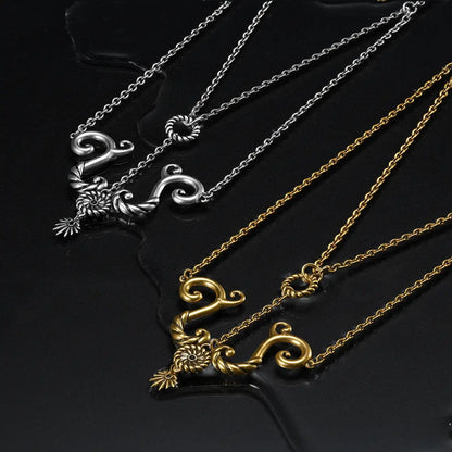 Sea witch inspired gold and silver layered necklaces displayed on dark aesthetic water ripples