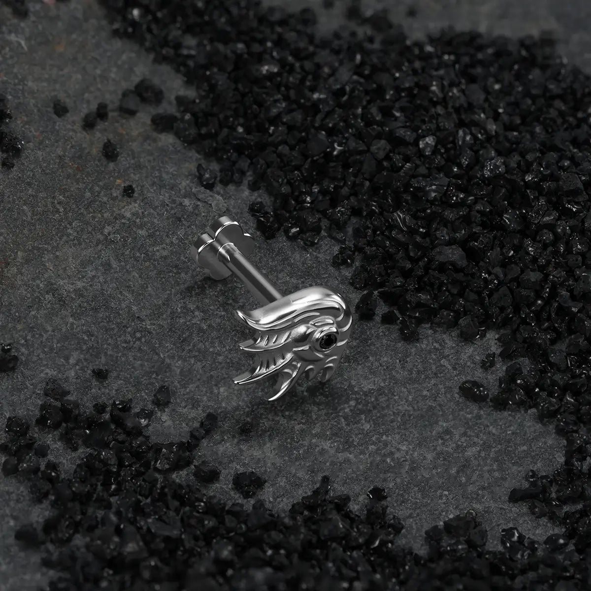 Natural titanium abyss conch flat back stud on textured dark coastal sand