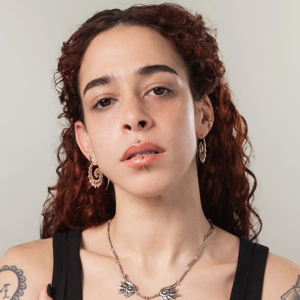 Model wearing the silver Nautilus Omen Earrings with a bold spiral profile, sharp shell details, and ocean-inspired gothic styling.