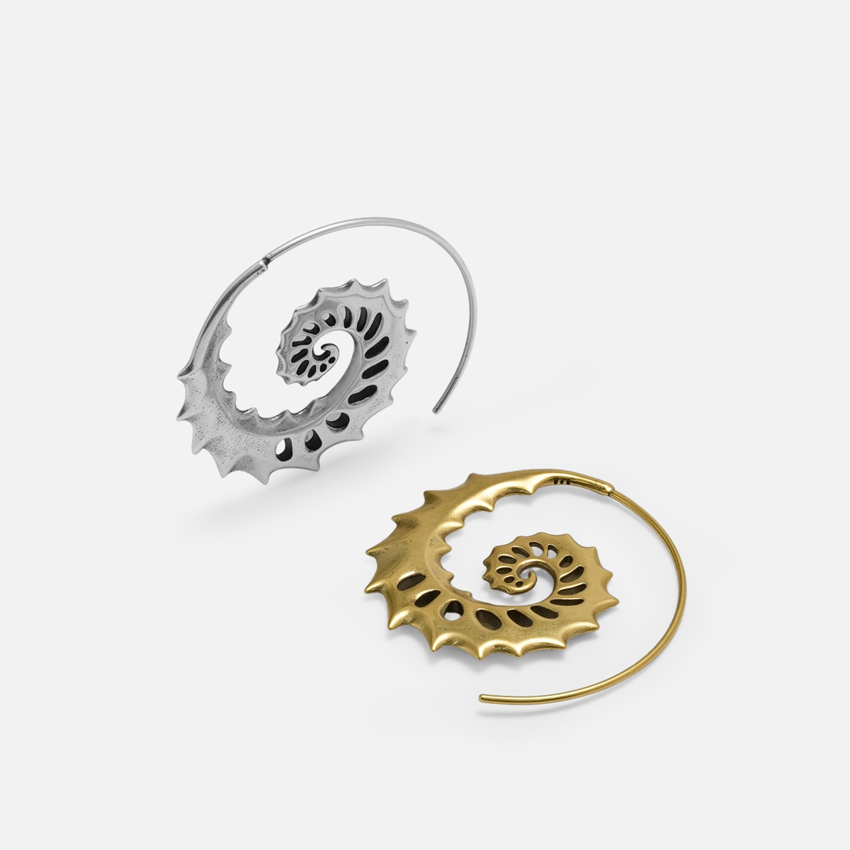 Silver and gold Nautilus Omen Earrings shown together, featuring spiral shell shapes, cutout ridges, and sharp thorn-like edges.