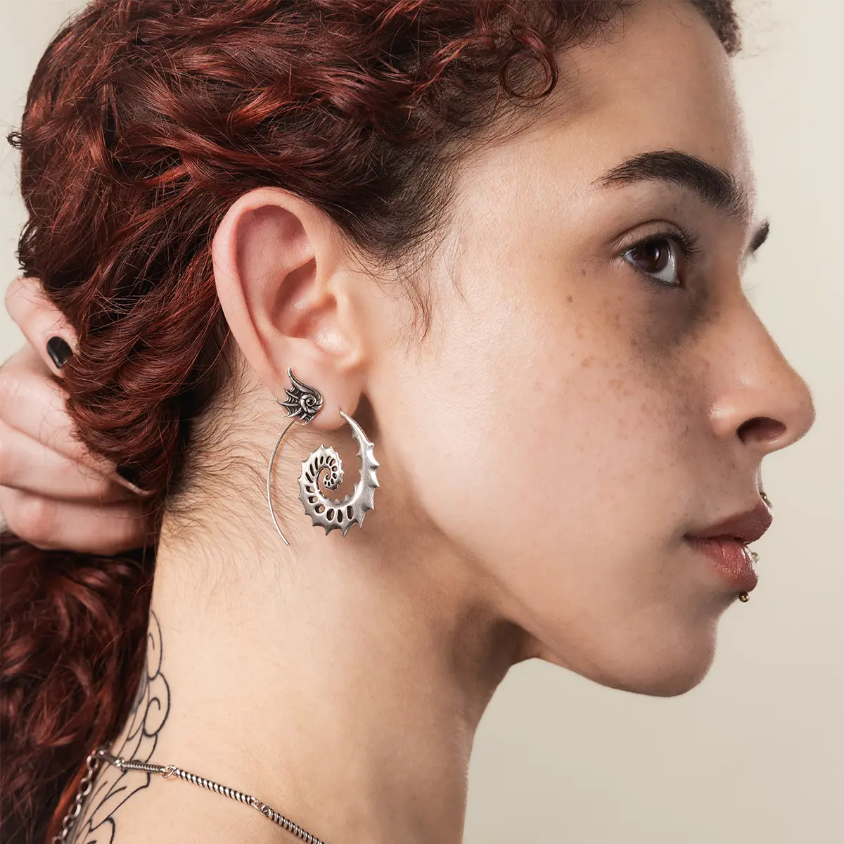 Side view of a model wearing the silver Nautilus Omen Earrings with sea-worn gothic styling and a sculptural spiral silhouette.