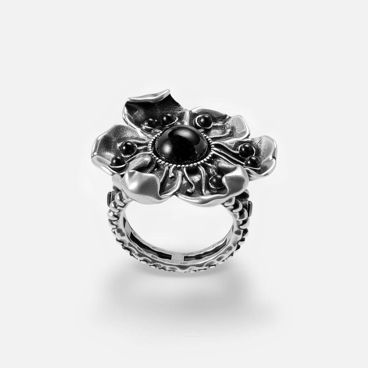 Silver-tone flower ring with black stone center and textured band, front view on white background