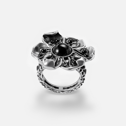 Silver-tone flower ring with black stone center and textured band, front view on white background