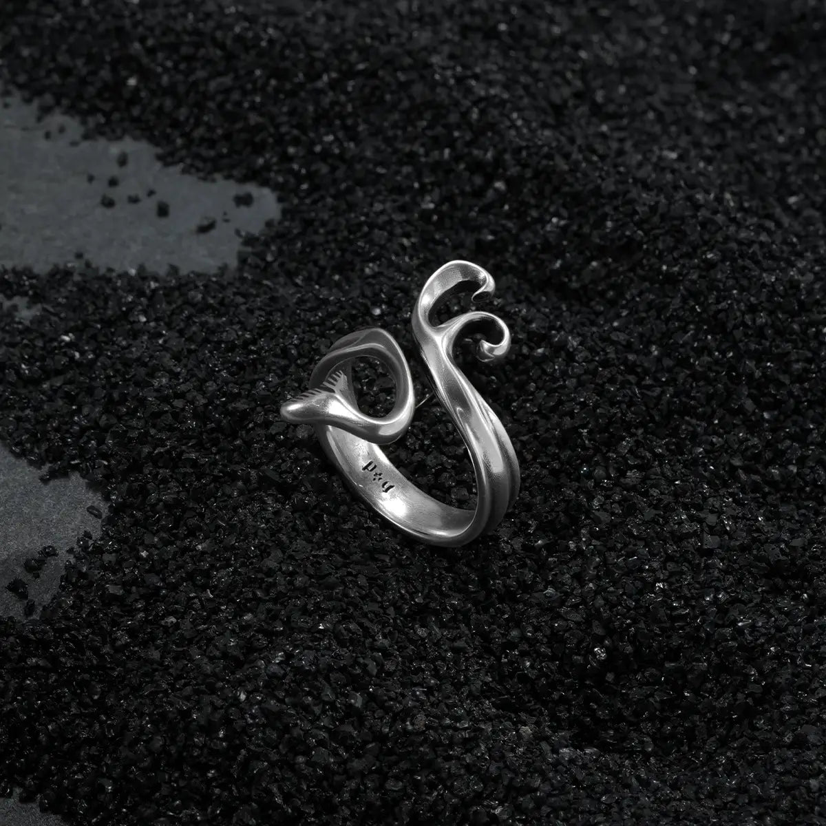 Ocean relic mythic siren ring featuring fluid silver curves on textured dark background