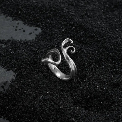 Ocean relic mythic siren ring featuring fluid silver curves on textured dark background
