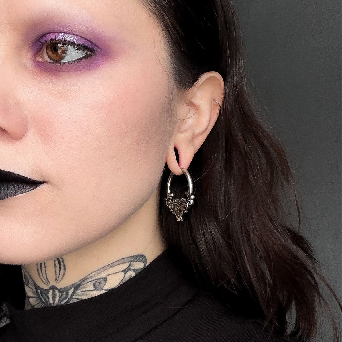Ornate Affection Earrings in 925 sterling silver, worn in a close portrait with purple eye makeup, black lipstick, and a neck