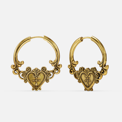 Pair of gold-tone hoop earrings featuring a heart and cross design with rose accents, front view