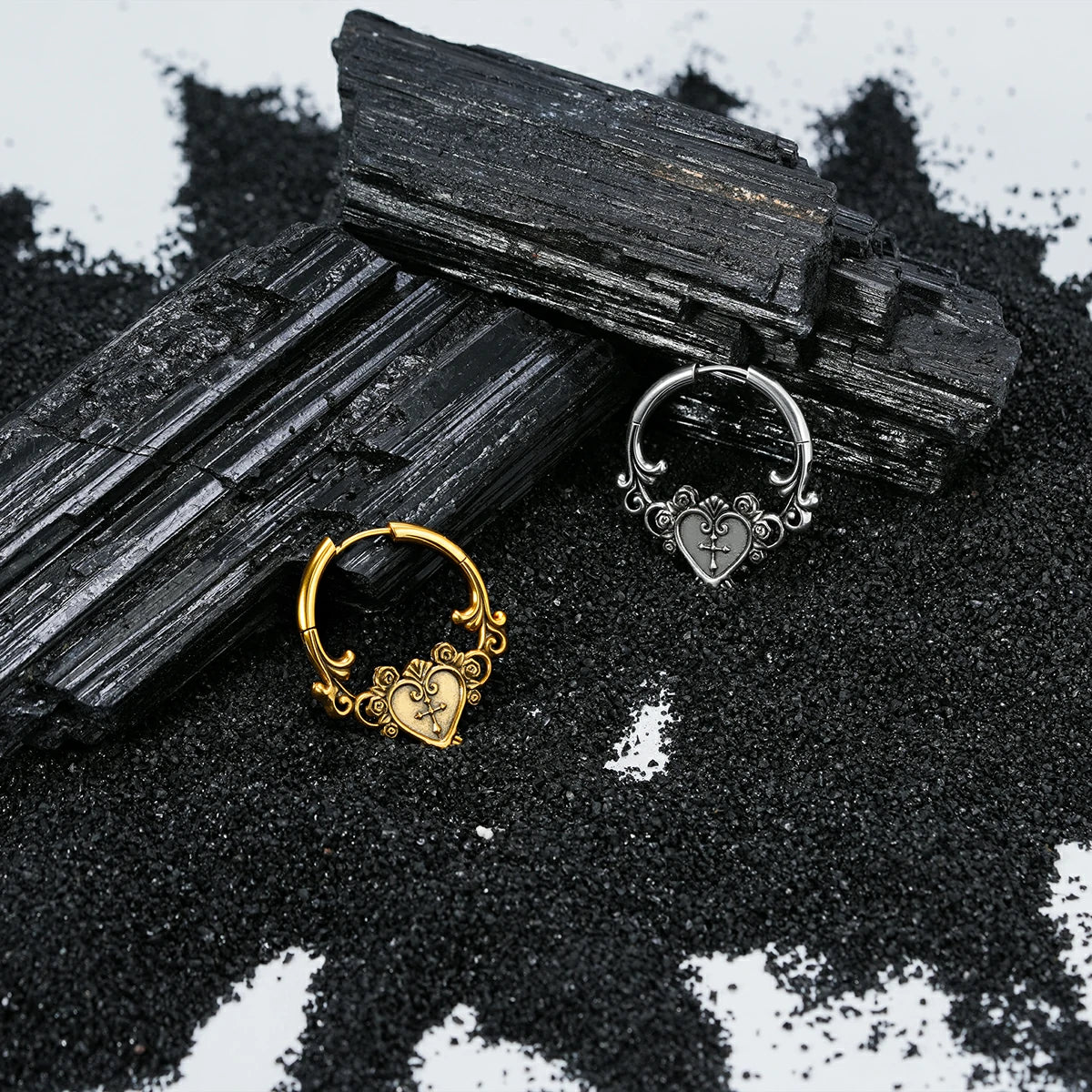 Silver and gold Ornate Affection hoop earrings displayed on black crystals