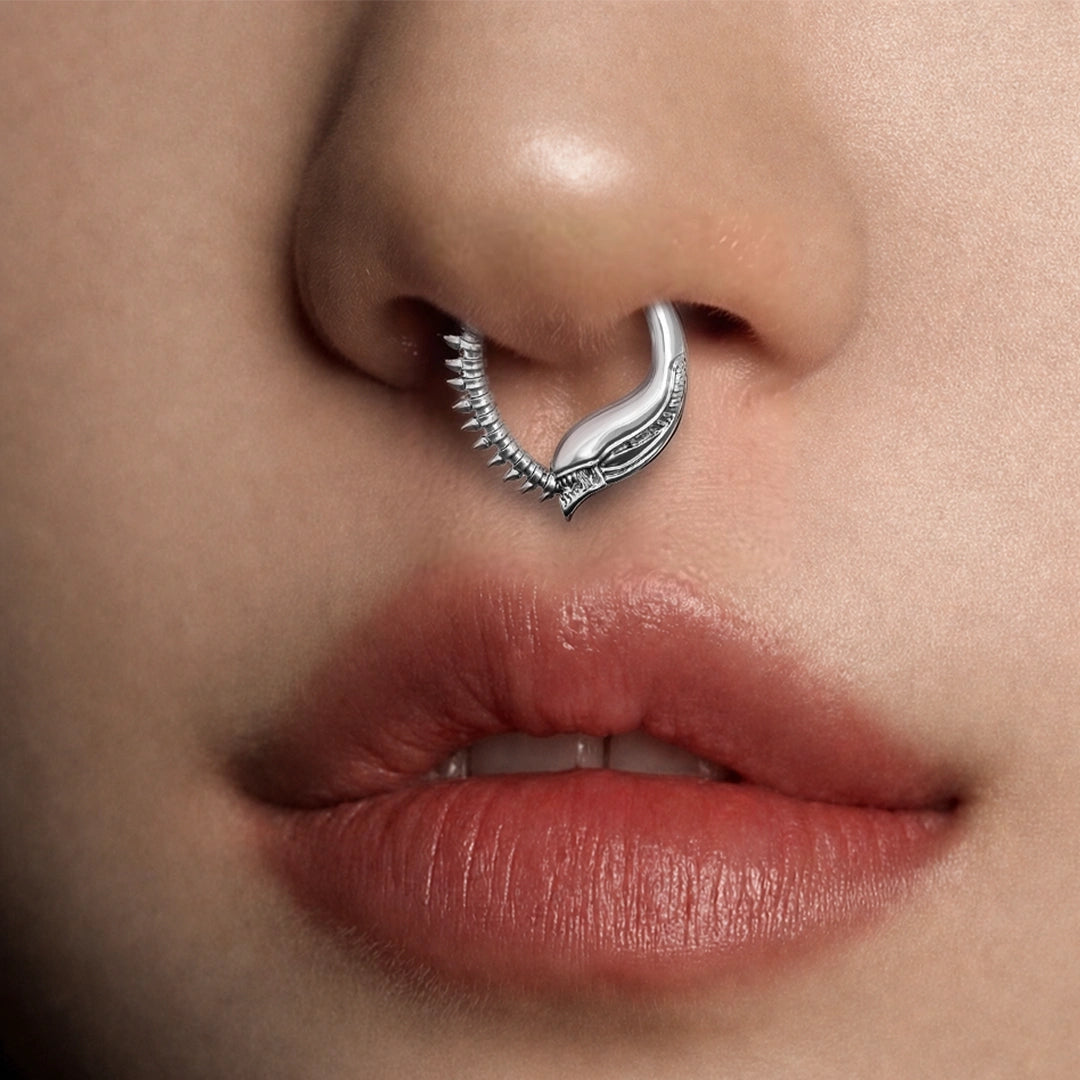 Silver-tone Ouroboros Clicker worn as a septum ring, featuring textured serpent-like ridges.