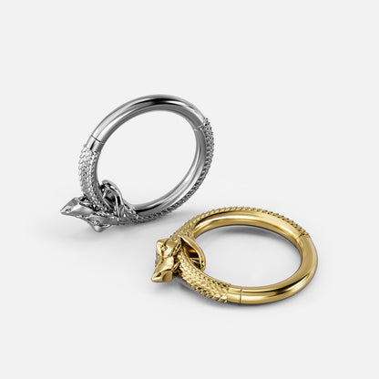 Silver and gold Ouroboros Coil clicker rings shown open and lying flat