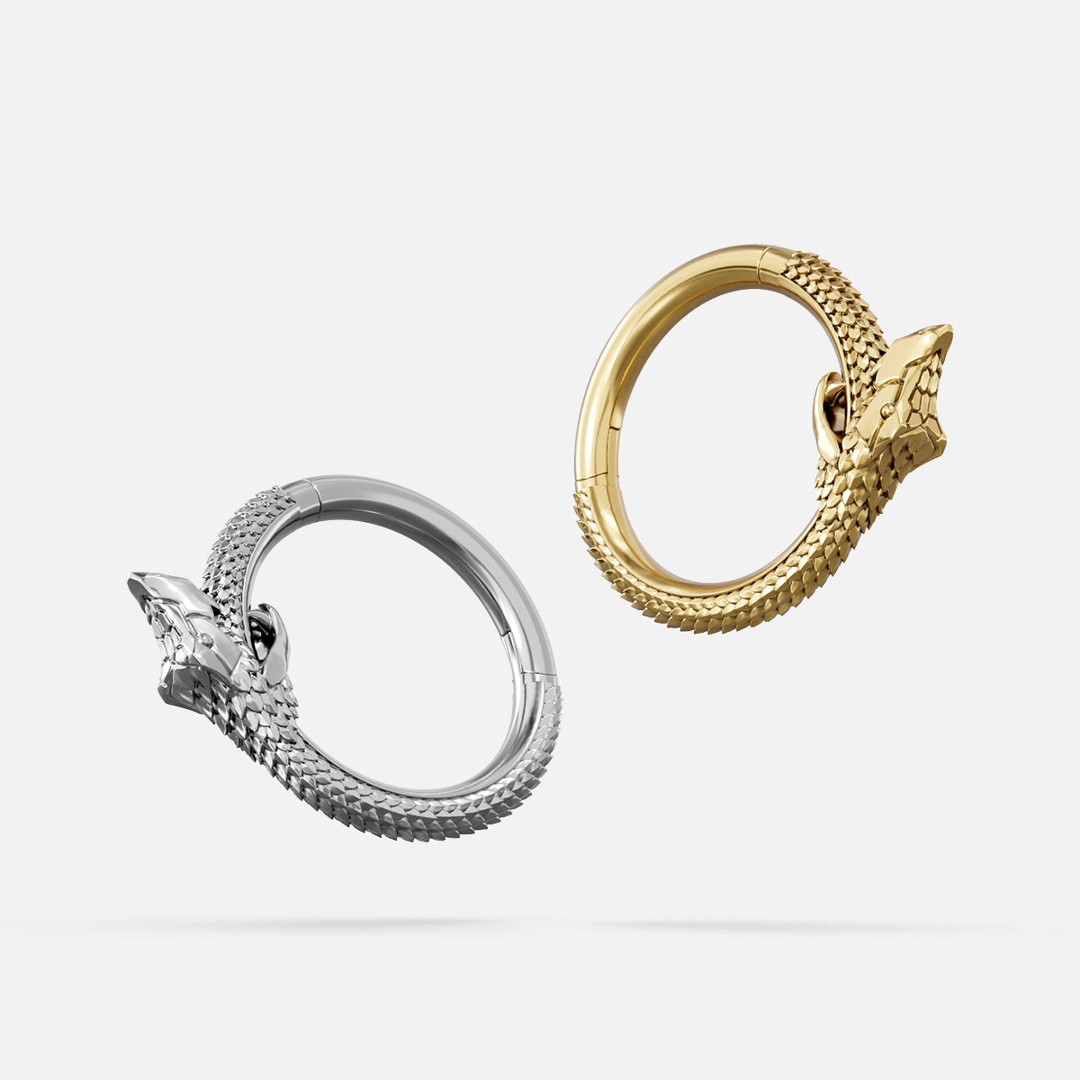 Silver and gold Ouroboros Coil clicker rings shown from side angles