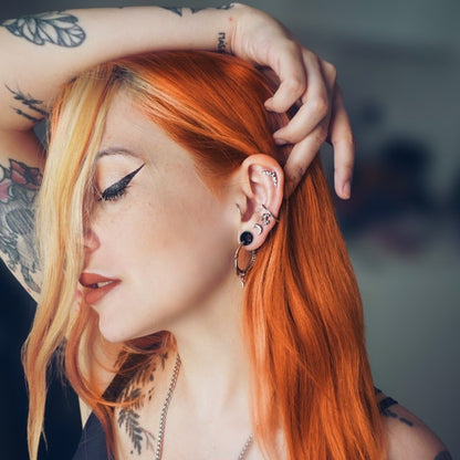 Red-haired model wearing a silver Ouroboros Dragon hoop earring