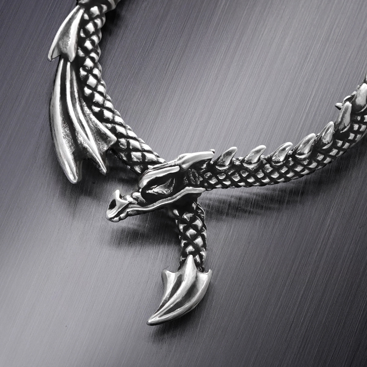 Close-up of silver Ouroboros Dragon hoop earring with sculpted dragon details