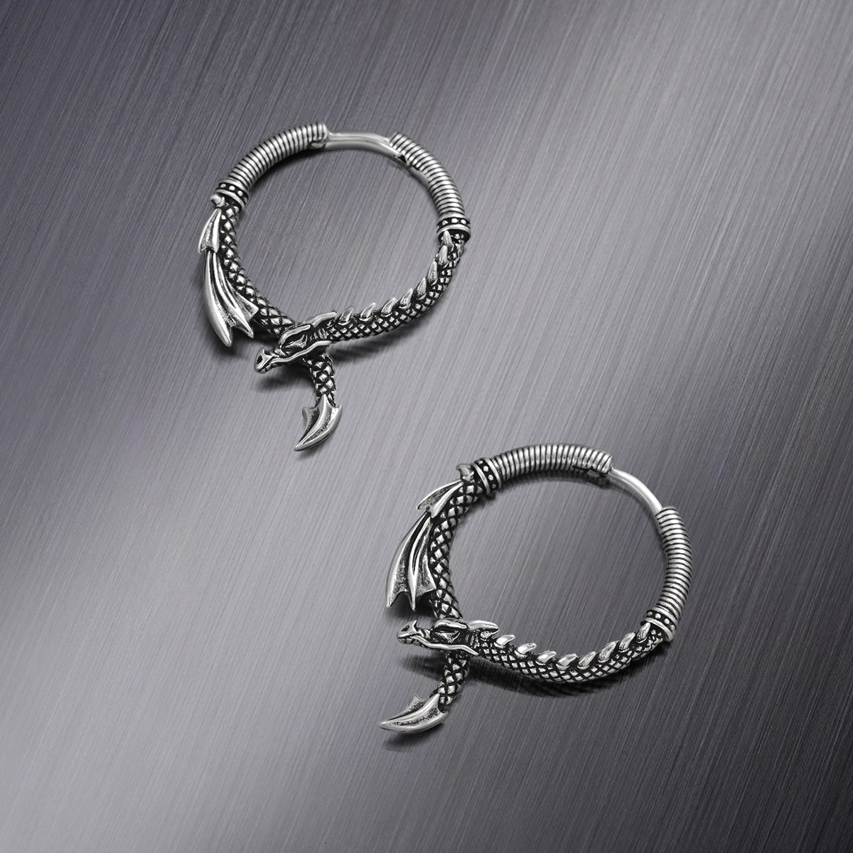 Two silver Ouroboros Dragon hoop earrings shown from different angles