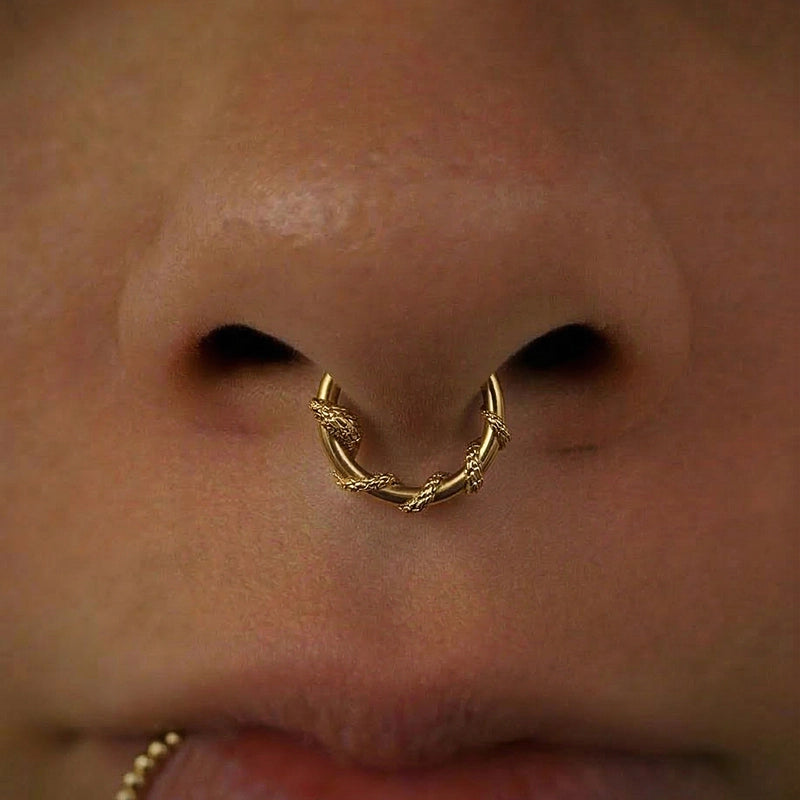 Gold-tone Ouroboros Serpent clicker worn in a septum piercing, close view of the twin snake motif
